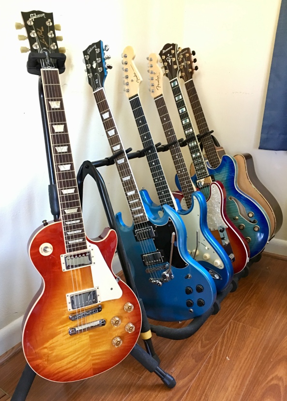 Gibsons, Fenders and Ibanez guitars on rack